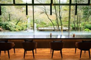 Takekara贺茂川庄日式旅馆的一个带椅子的酒吧,享有喷泉的景色