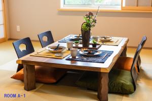 箱根MEIBI Hakone Yumoto的一张木桌,上面有盘子和盘子