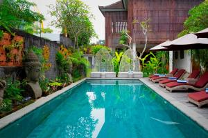 乌布Freddies Villas Ubud Bali的花园内的游泳池,带躺椅