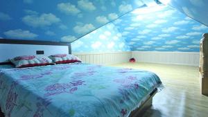 统营市Tongyeong Bada Sarang Pension的一间卧室设有一张蓝色天花板的大床