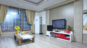 统营市Tongyeong Bada Sarang Pension的客厅配有平面电视和桌子。