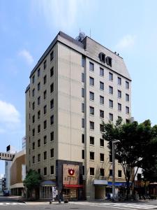 名古屋Hotel S-plus Nagoya Sakae的一条城市街道上高大的白色建筑