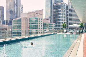 新加坡Capri by Fraser China Square, Singapore的在城市游泳池游泳的人