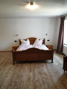 科伯恩-贡多夫Gastehaus in der Alte Kellerei的一间卧室配有一张带白色床单和枕头的木制床。
