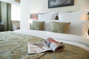 埃里温阿尼广场酒店的一间酒店客房,配有一张带杂志的床