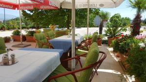 Hrvace扬科维奇汽车旅馆的一间带桌椅和遮阳伞的餐厅