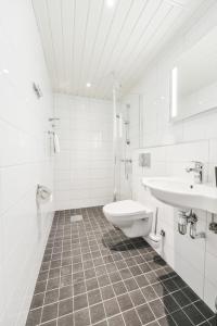 埃克奈斯海滨酒店的白色的浴室设有水槽和卫生间。