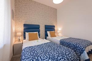 普拉S. Martino Rooms的蓝色和白色的客房内的两张床