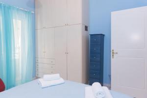 卡拉马塔Palina's comfy home.的卧室配有白色的床和蓝色的墙壁