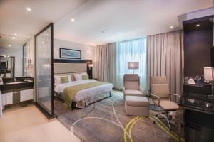 内罗毕内罗毕迦南皇家郁金香酒店的配有一张床和一张书桌的酒店客房