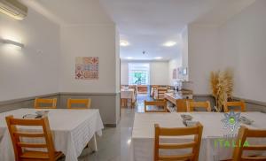 里斯本意大利酒店的一间设有白色桌椅的用餐室