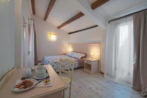 威尼斯Palazzetto Canossa的一间房间,配有一张床和一张桌子,上面有食物