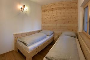 奥西亚歇尔湖畔施泰因多夫Villa Stiegl的木墙客房的两张床