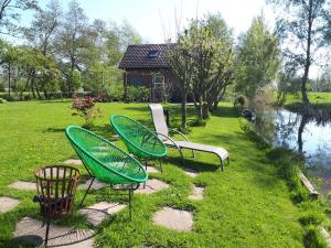羊角村Huisje Beukers的一群椅子坐在池塘附近的草地上