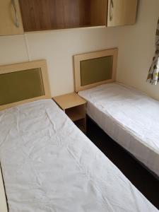 西卢港Caravan Willerby Rio的小房间设有两张床,带两张床。