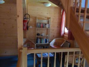 莫尔金斯瑞士小木屋住宿加早餐酒店的小木屋内的楼梯,配有椅子和书架