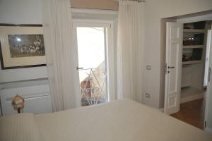 塔尔奎尼亚Camere con vista (Rooms with a view)的一间卧室设有一张床,并有通往阳台的门