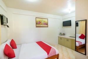 马尼拉Conrado's Apartelle的一间卧室配有一张带红色枕头和镜子的床