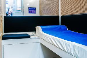卡塞勒蒂索玛坎普Resting Pods - ZzzleepandGo VRN Verona Airport的一间设有一张蓝色毯子的床的客房