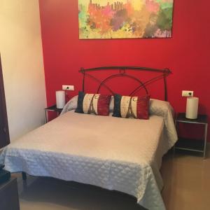 桑卢卡尔-德巴拉梅达Playa de Las Piletas的一间卧室配有一张红色墙壁的床