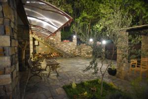 卡托劳塔翁Santa Marina Guesthouse的石头庭院配有桌子和遮阳伞