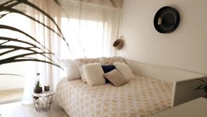 塞特港BoHémian Studio in Sète Center的卧室配有带枕头的床铺和窗户。