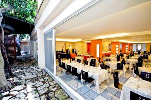 托雷瓦多Cala Saracena Resort的一间设有白色桌椅的用餐室