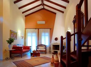 阿卡尼斯卡塔拉加里乡村套房酒店的客厅配有红色椅子和沙发