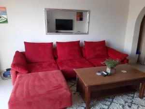 QbajjarPenthouse view的客厅里一张红色的沙发,配有桌子