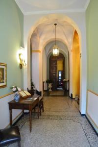 诺利皇家学院酒店的一间设有桌子的房间和一个带拱门的走廊