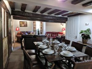 斯特劳德Cotswolds Valleys Accommodation - Medieval Hall - Exclusive use character three bedroom holiday apartment的一间带桌子和沙发的用餐室