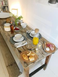 Penne-dʼAgenaisl'autre maison的一张带早餐食品和橙汁的木桌