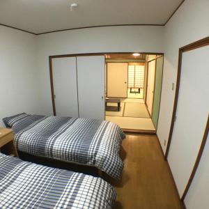 桑名市machiyado Kuwanajuku Kawaguchi-cho 8的配有镜子的客房内的两张床