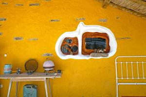 奥德米拉The Hobbit House - Montes da Ronha的客房内的黄色墙面,窗户
