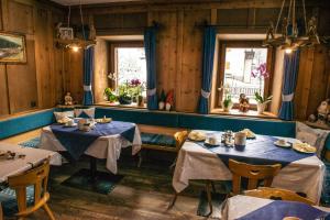 塞斯托Landhaus Summerer的餐厅设有2张桌子和2个窗户