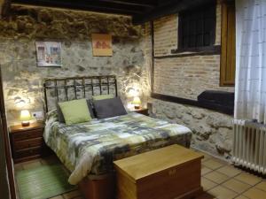 坎德拉里奥Hotel La Casa Chacinera的石墙客房的卧室配有床