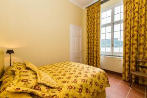 富尔纳斯杜斯巴尔科斯弗纳斯度假屋的一间卧室配有一张带黄色棉被的床和窗户