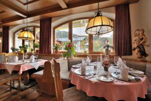 柯尼希斯湖畔舍瑙伯格马特酒店的一间带2张桌子和吊灯的用餐室
