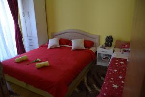 巴伊纳巴什塔Relax Apartment的一间卧室配有红色的床和红色毯子