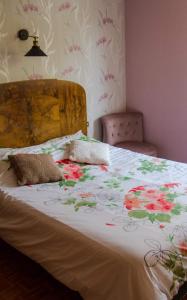 TaintruxChticabane的一张带花卉被子的床铺,床上配有两个枕头
