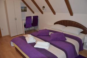 普利特维采湖克内热维奇别墅酒店的一间卧室配有两张床、紫色床单和毛巾