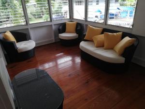 甘博阿Casa completa en Gamboa, Canal de Panamá的客厅配有3把椅子和1张沙发