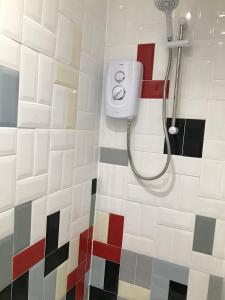 梅奈布里奇Nant Apartment - Ground Floor的浴室设有红色白色和黑色瓷砖淋浴。
