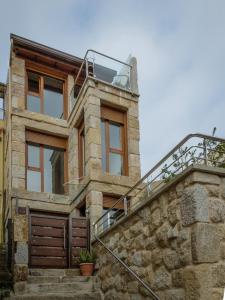 坎加斯德穆拉索Casa do Outeiro的一座石头房子,设有玻璃屋顶和楼梯
