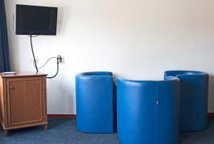 阿姆斯特丹亨德里克王子酒店的配有电视的房间,设有两把蓝色椅子