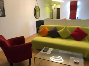 克卢日-纳波卡RELAX Cluj Apartment and Terrace的客厅配有带色彩缤纷枕头的绿色沙发