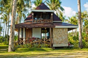 CaluwayanCaluwayan Palm Island Resort & Restaurant的一座小房子,拥有门廊和棕榈树