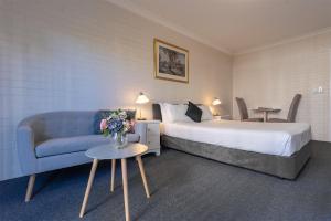 布里斯班本森庭院汽车旅馆的酒店客房,配有床和沙发