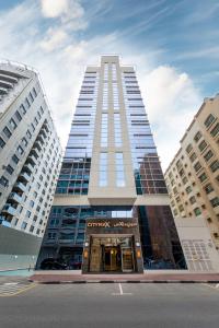 迪拜Citymax Hotel Al Barsha的一座高大的建筑,有建筑物的入口