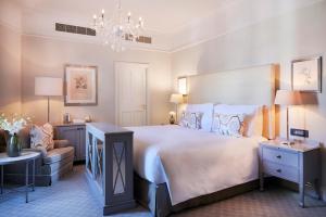 开普敦Mount Nelson, A Belmond Hotel, Cape Town的一间卧室配有一张大床和一个吊灯。